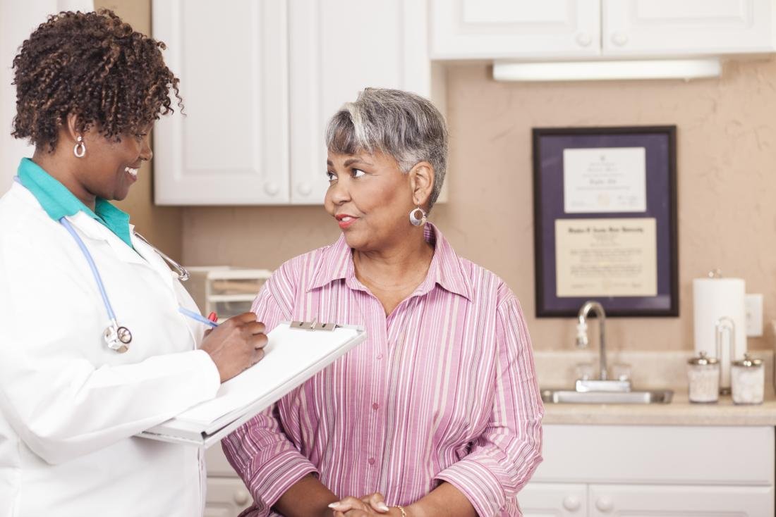 Mature female patient speaking to female doctor,